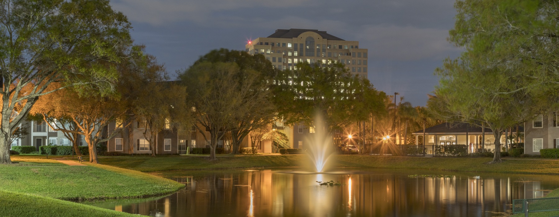 pond with fountain lit at night