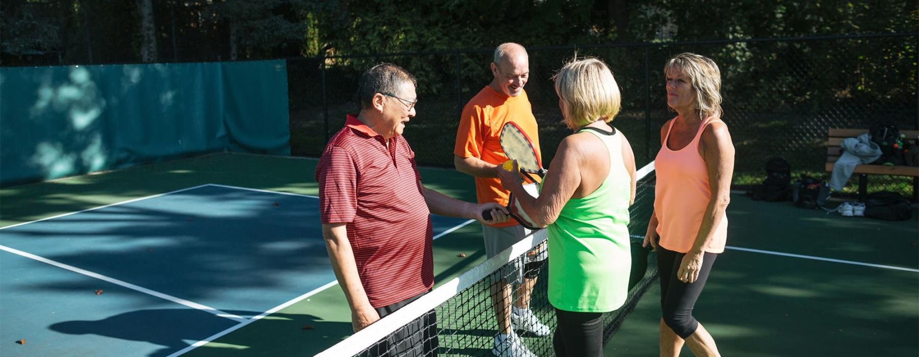 a group of people standing on a Pickleball court